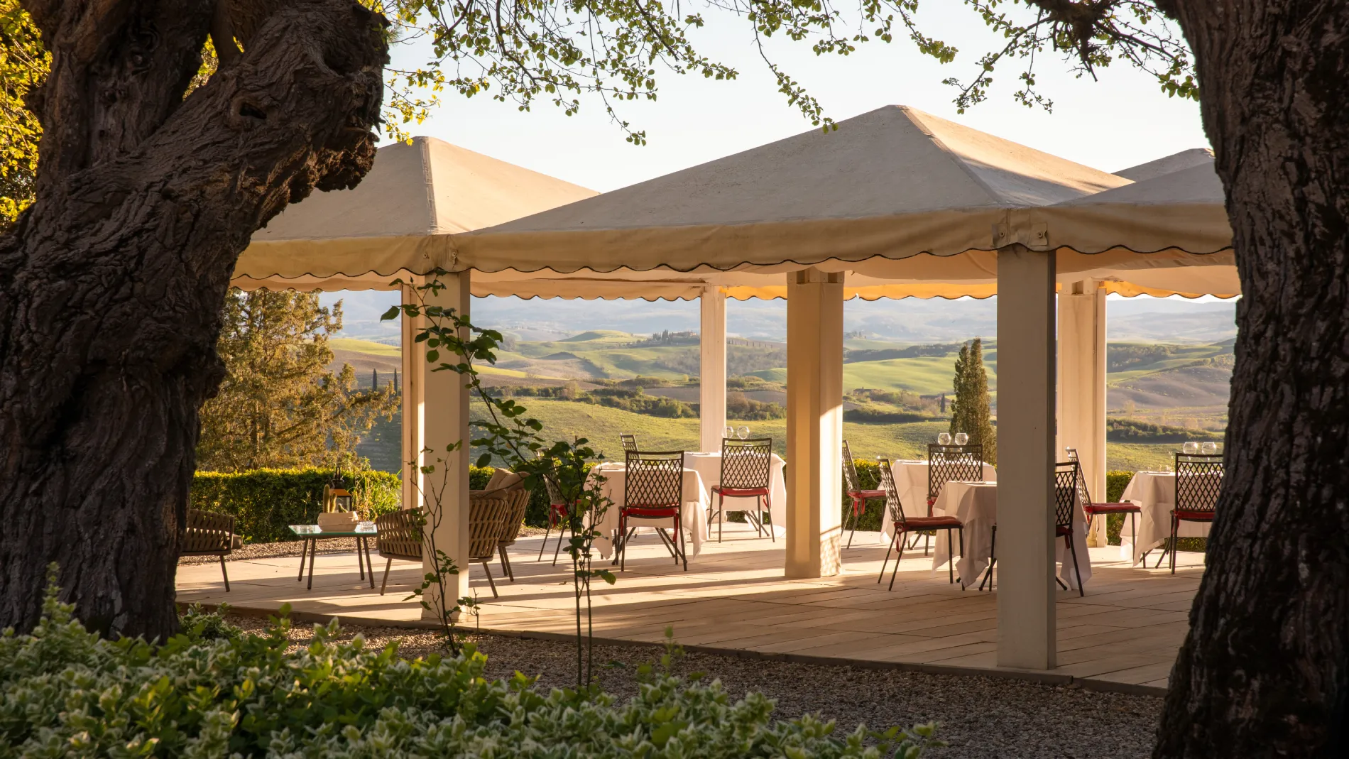 Panoramic terrace with outdoor tables overlooking the rolling hills of Sienese Tuscany in the Crete Senesi - Castello di Leonina, BZAR hotels in Tuscany