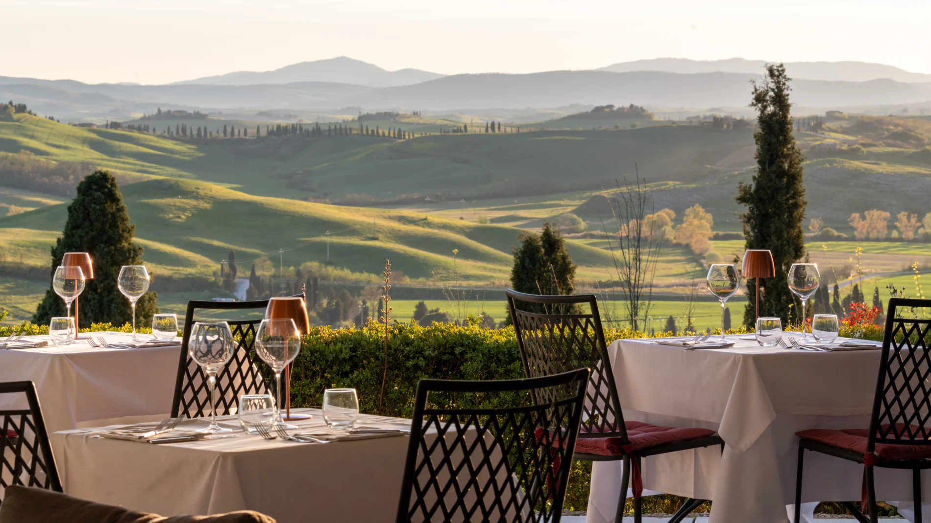 Outdoor dining on the terrace with set tables and views over the Tuscan countryside in Asciano - Castello di Leonina, BZAR hotels in Tuscany