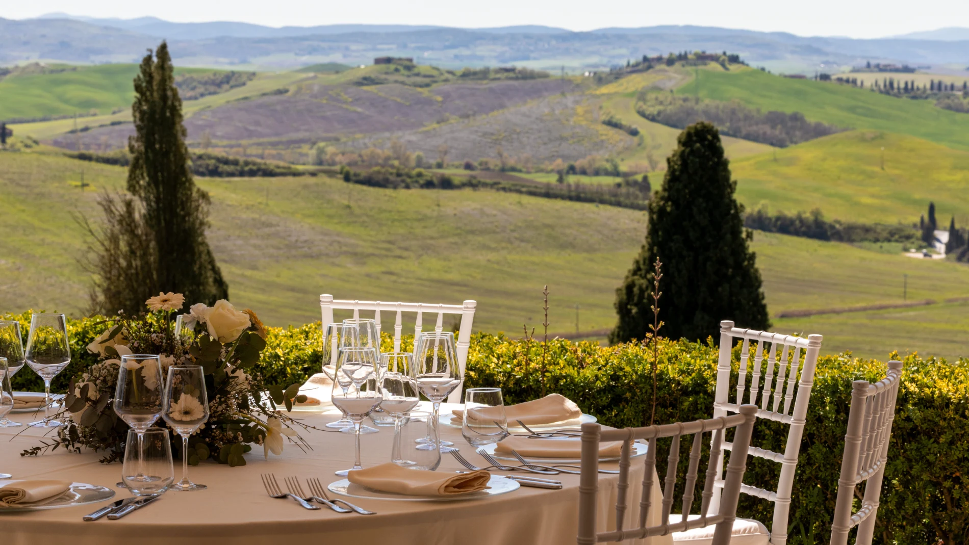 Wedding setup on panoramic terrace with elegant tables overlooking the Crete Senesi hills in Asciano - Castello di Leonina, BZAR hotels in Tuscany