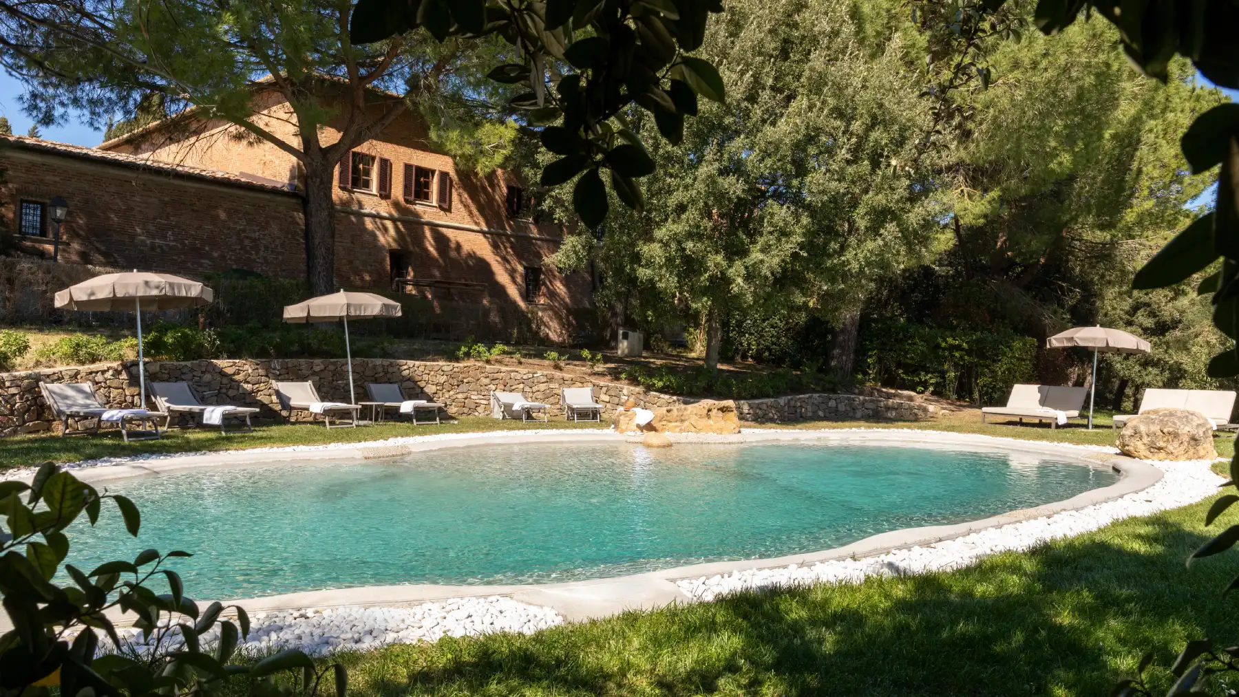 Panoramic pool with sun loungers and umbrellas set in the green Tuscan countryside of Asciano - Castello di Leonina, BZAR hotels in Tuscany