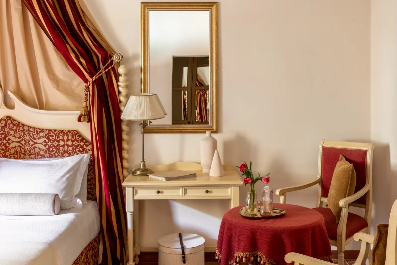 Detail of a charming room in Asciano with canopy bed, writing desk and elegant sitting area in Tuscan style - Castello di Leonina, BZAR hotels in Tuscany
