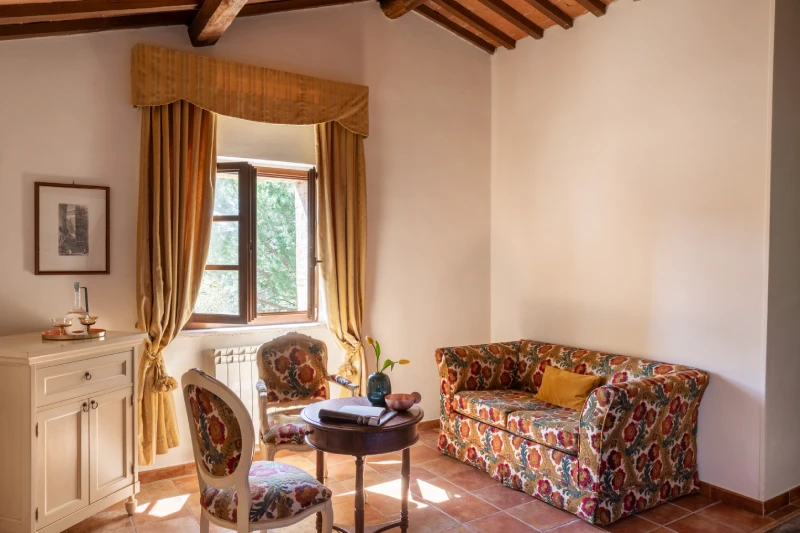 Suite with sitting area in Asciano, floral sofa, bright window and classic details in a charming Tuscan relais - Castello di Leonina, BZAR hotels in Tuscany