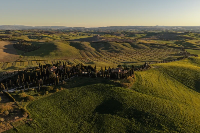 Veduta aerea sulle Crete Senesi con Castello di Leonina circondato da colline toscane e filari di cipressi ad Asciano - Castello di Leonina, BZAR hotels in Toscana