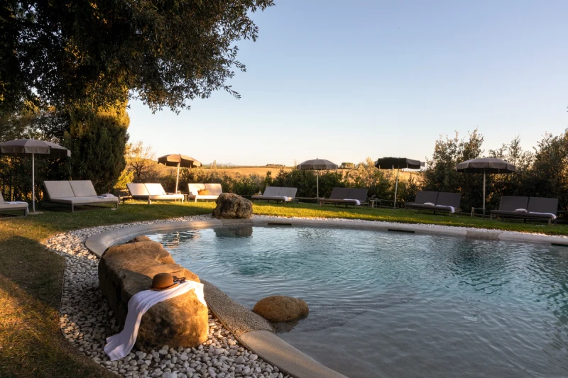 Piscina panoramica con lettini e ombrelloni immersa nella campagna toscana di Asciano, ideale per momenti di relax - Castello di Leonina, BZAR hotels in Toscana