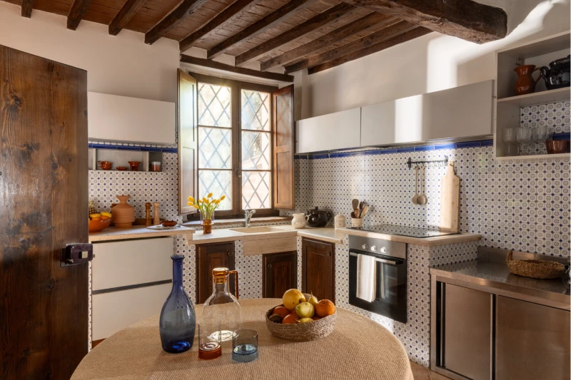 Cucina rustica della Villa Annex Adults Only con travi a vista e piastrelle decorate nelle Crete Senesi - Castello di Leonina, BZAR hotels in Toscana