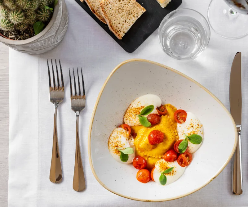 Gourmet Tuscan dish by chef Mirko Vaselli with fresh pasta, cherry tomatoes and refined presentation in a restaurant in Asciano - Castello di Leonina, BZAR hotels in Tuscany