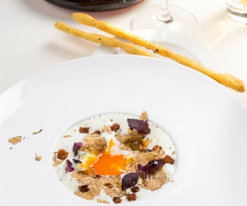 Egg with truffle and creamy sauce from chef Mirko Vaselli’s truffle menu, gourmet dining experience in Tuscany - Castello di Leonina, BZAR hotels in Tuscany
